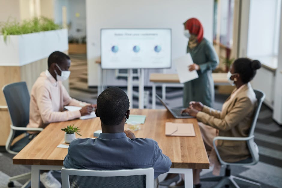 Diverse team in a modern office discussing a presentation in a conference room setting.